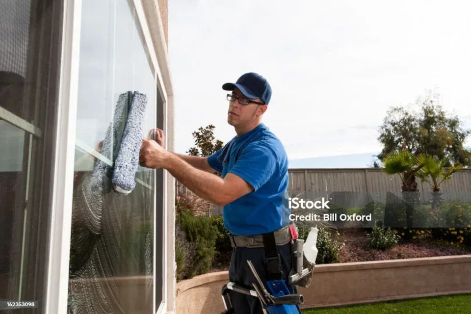 Technician cleaning an exterior window